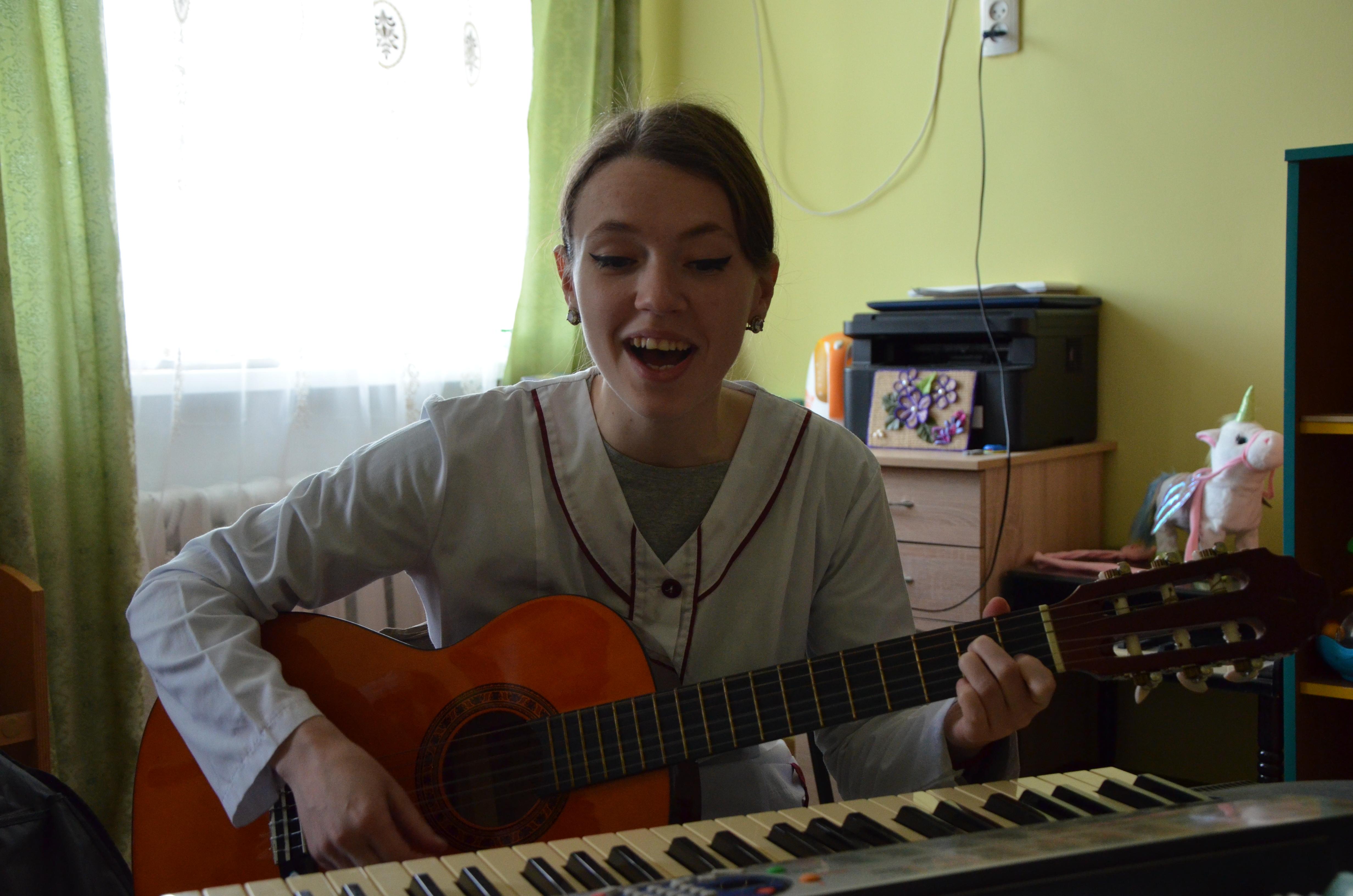 Вихователька Тетяна Валько грає для дітей на гітарі