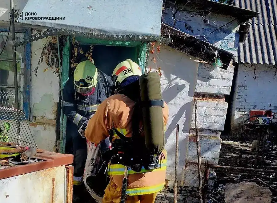 Тіло чоловіка виносять рятувальники з пожежі у Кропивницькому районі