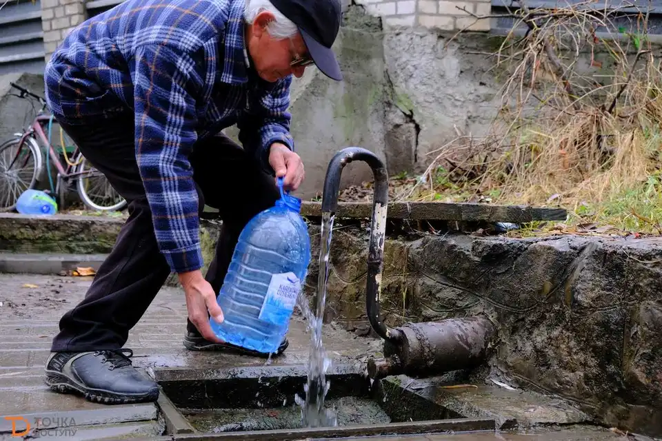 чоловік набирає воду