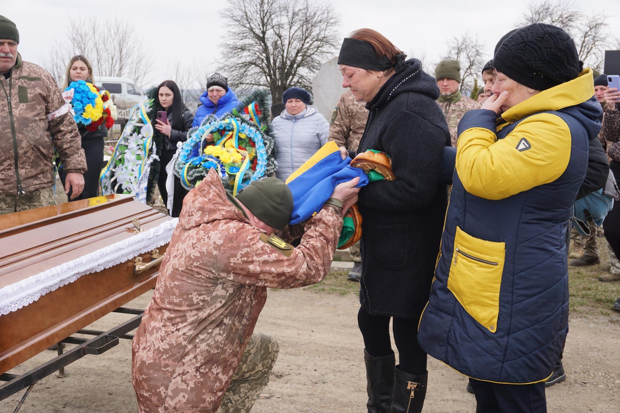 Боєць віддає стяг родичам Марата Гасанова