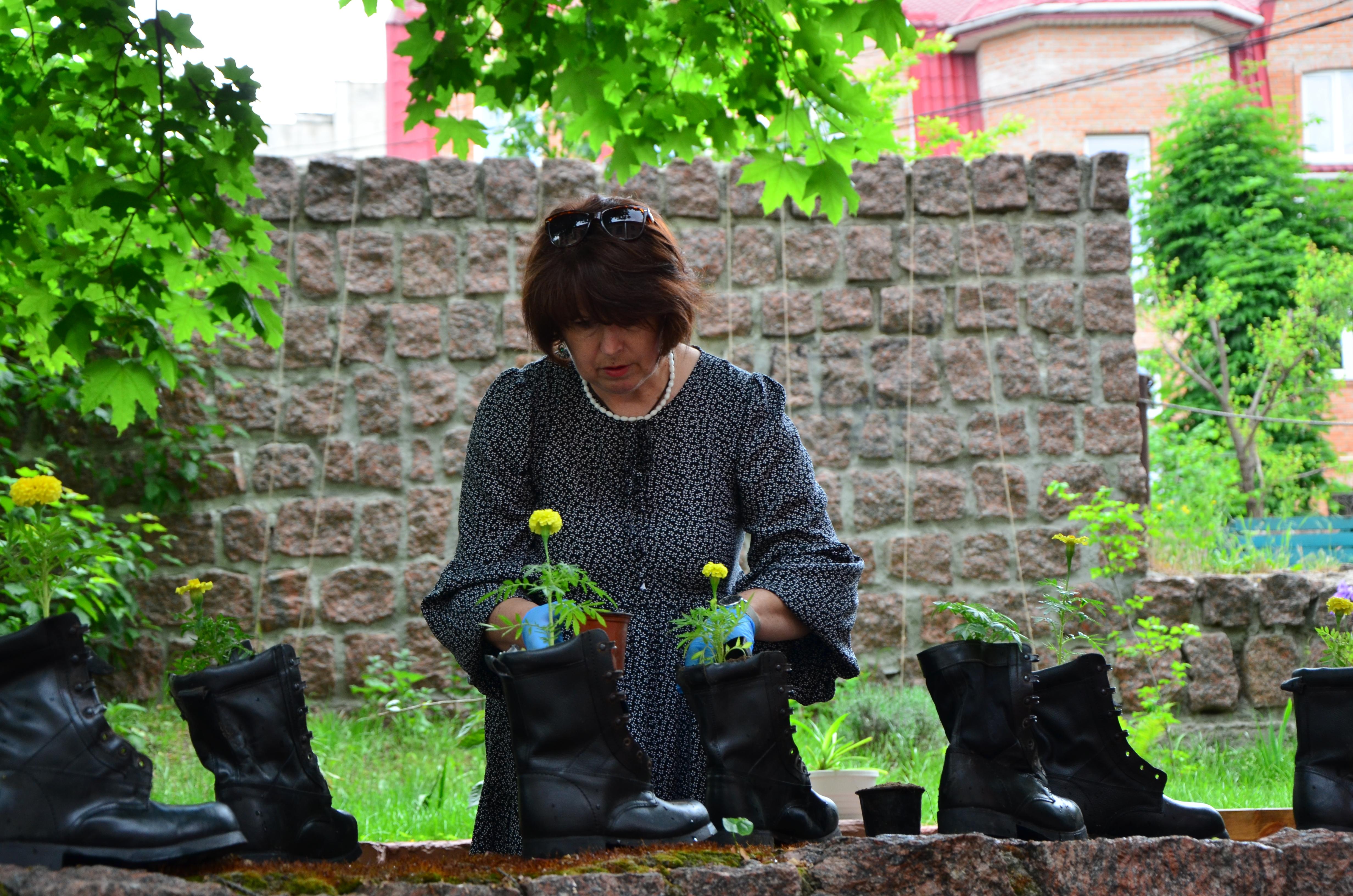 Жінка садить квіти