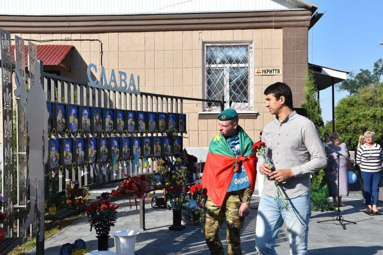 Селищний голова вручає прапор громади морському піхотинцю Костянтину Пічкуру