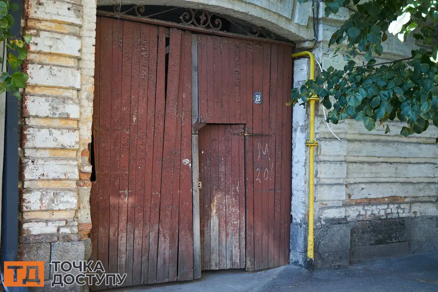 Будинок № 28 по вулиці Чорновола, відомий як лікарня Когана. Над дерев’яними воротами, які закривають проїзд на подвір’я, металева вставка.