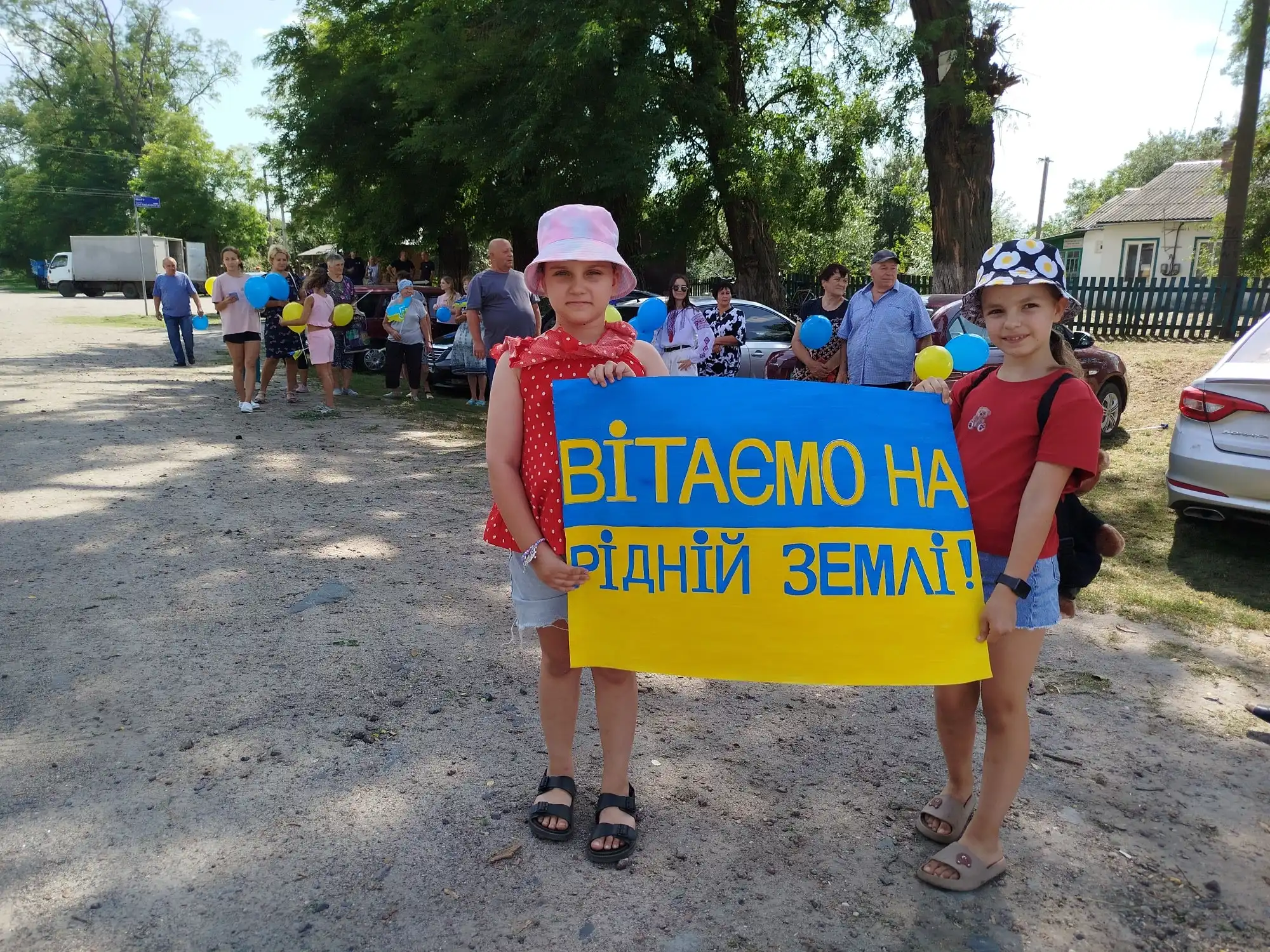 Діти тримають плакат "Вітаємо вдома"