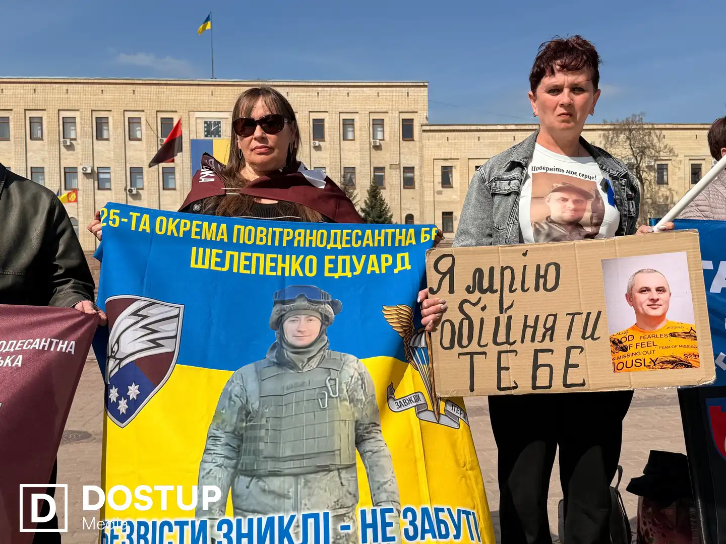 Люди стоять із плакатами на вулиці Великій Перспективній